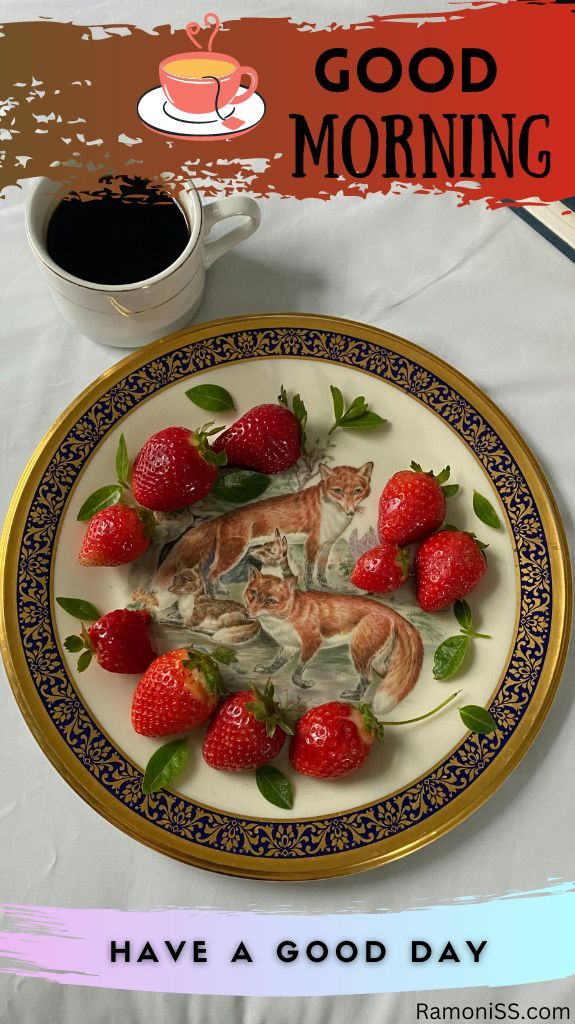 The photo has strawberries in a printed plate of the fox on a white table and also a cup filled with black tea.