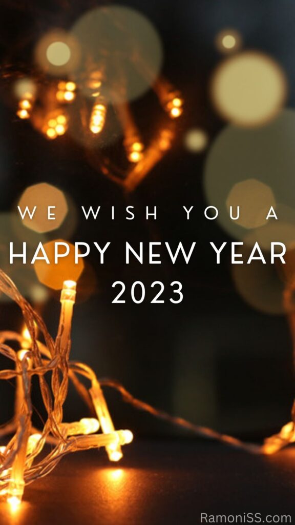 Happy new year 2023 on photo created using decorated yellow light bulb and white font on colorful background.
