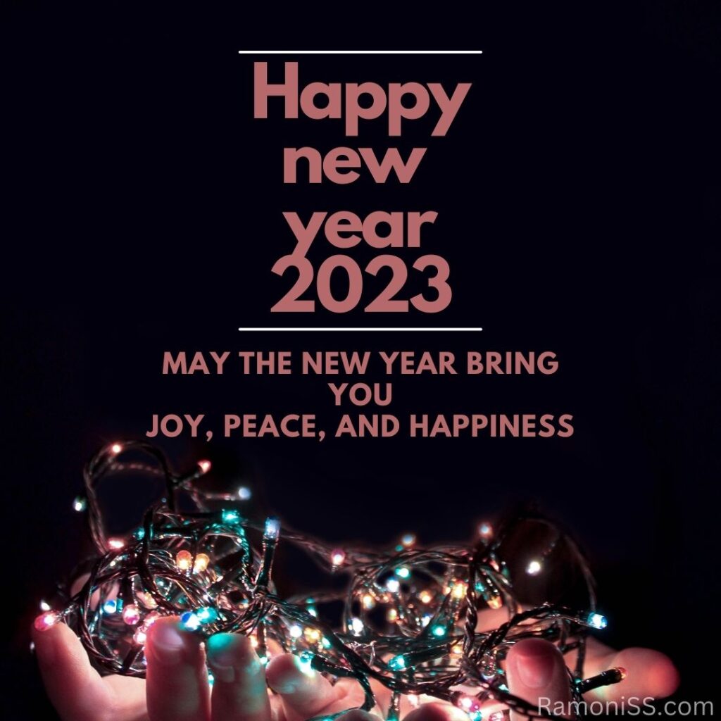 Happy new year 2023 using light pink font, on decoration bulb on the hands and colorful background
