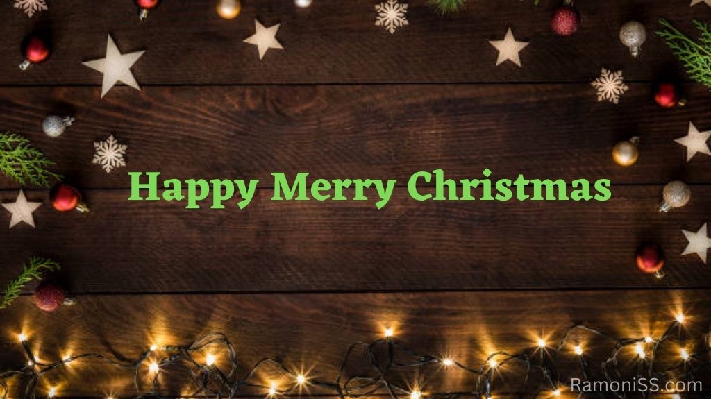 The wooden background is decorated with stars, christmas balls, light bulb fringe, and christmas tree leaves, and happy merry christmas is written in green using stylish fonts.
