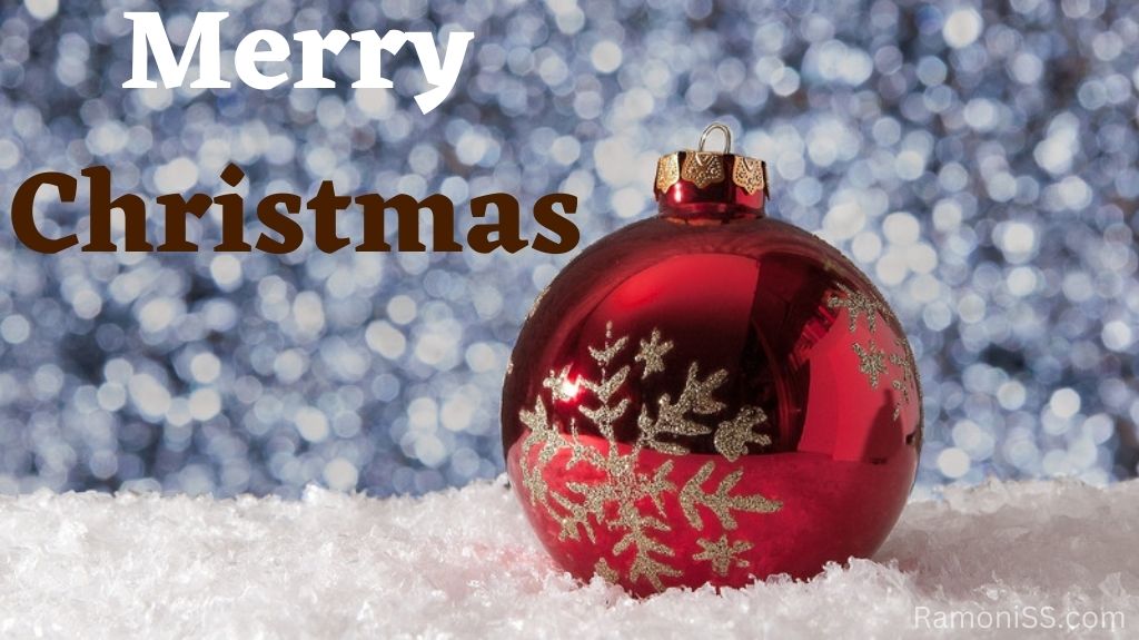 Red christmas ball on foam in front of a glittery background, and merry christmas written in a stylish white font on the christmas ball.