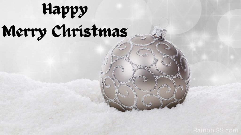 A gray christmas ball is placed on the foam in front of a beautiful white background, and in the photo reads "happy merry christmas" in stylish black font.