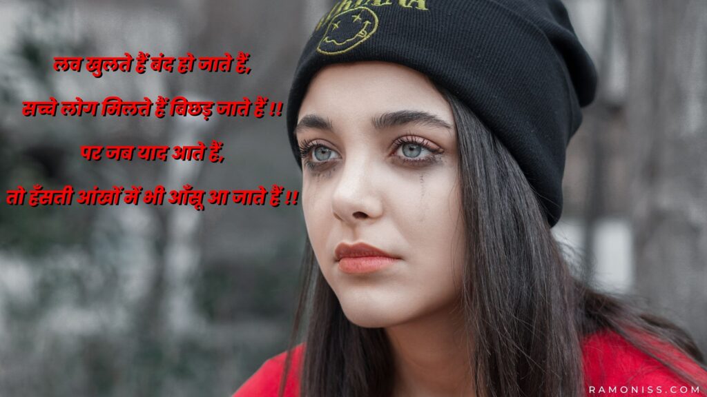 A sad girl wearing a red sweater and black cap is sitting in the background of the photo, who is looking very sad, a sad poetry is also written in the photo.