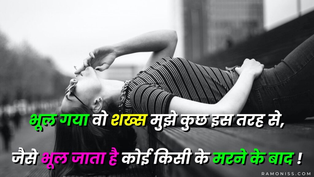 In the black and white background of the photo, a sad girl in black dress is lying down and smoking a cigarette, which looks very sad, a sad shayari is also written in the photo.