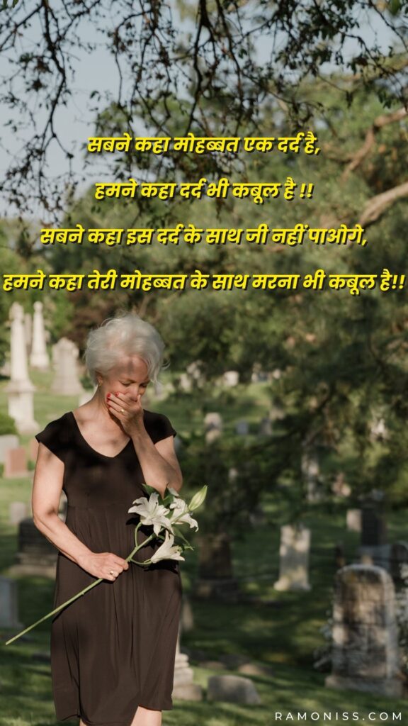 An old woman is crying hard in the cemetery, who also has a flower in her hand and is very sad
