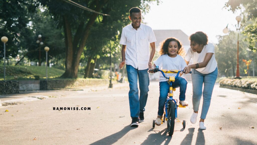 Happy mother and father teaching their daughter to ride a bicycle