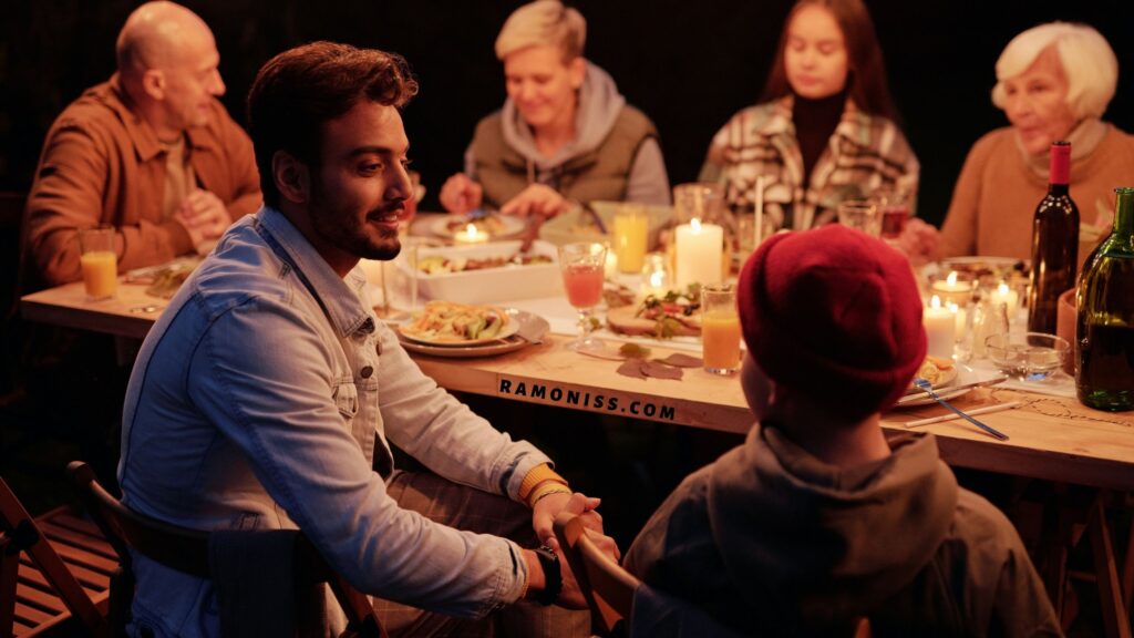 In the photo, all the members of a happy indian family are having dinner together and talking to each other.