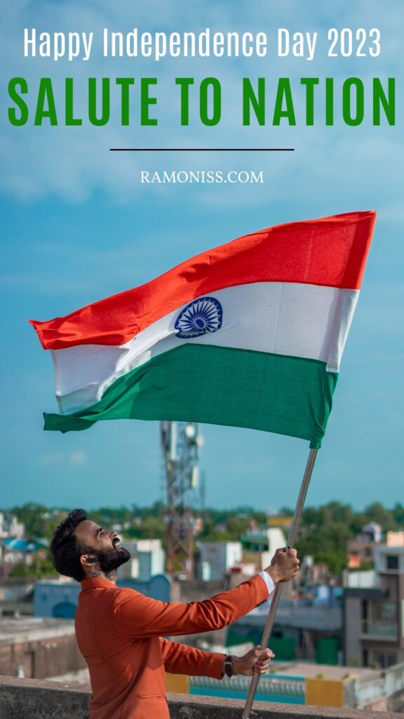 In this picture of happy independence day, a man wearing a red coat is hoisting the indian flag on the roof of his house.