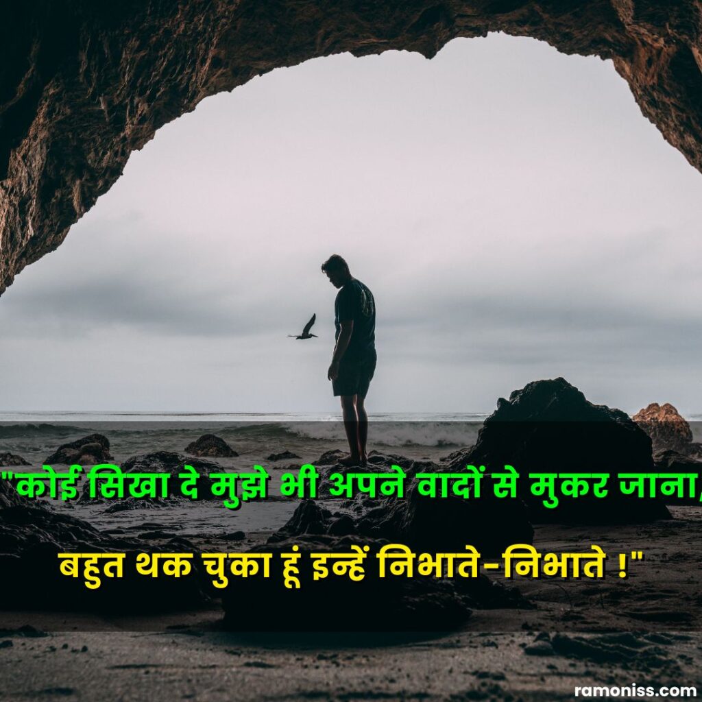 In the image, sad alone man standing on rock near the seashore sad quotes in hindi are also written.