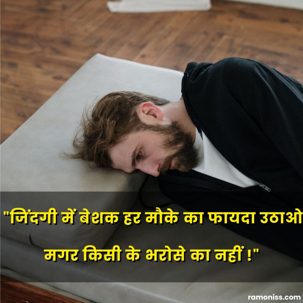 In the photo, a sad lonely man in black long-sleeve shirt lying on the grey couch and sad quotes in hindi are also written.
